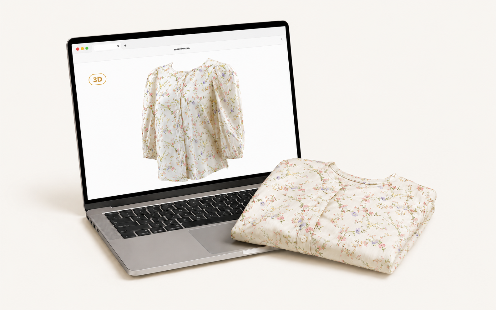 A folded floral blouse resting on a cream surface beside an open laptop, the laptop displaying the same garment as an interactive 3D Twin in a browser.